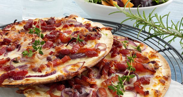 https://imgix.udeoghjemme.dk/media/websites/udeoghjemme-dot-dk/website2/2013/marts/10/webredaktion/mad/10-pizza-med-loeg-og-bacon-612_0.jpg