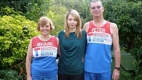 Moarg mellem sin mor, Mhairi, og far, Peter, som løber et halvmaraton i kampen mod kræft.